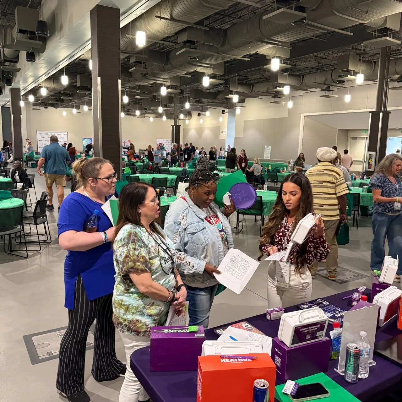 Attendees exploring ONEbox and HEATbox™ at a community expo